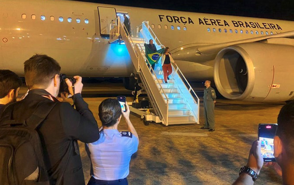 Desembarque dos primeiros brasileiros repatriados na Base Aérea de Brasília: bandeira nacional em punho, em segurança. Foto: Vinicius Neves / Secom / PR